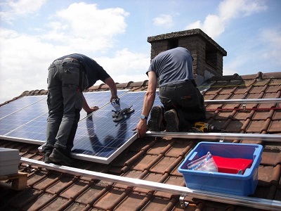 Men installing solar panels on a roof