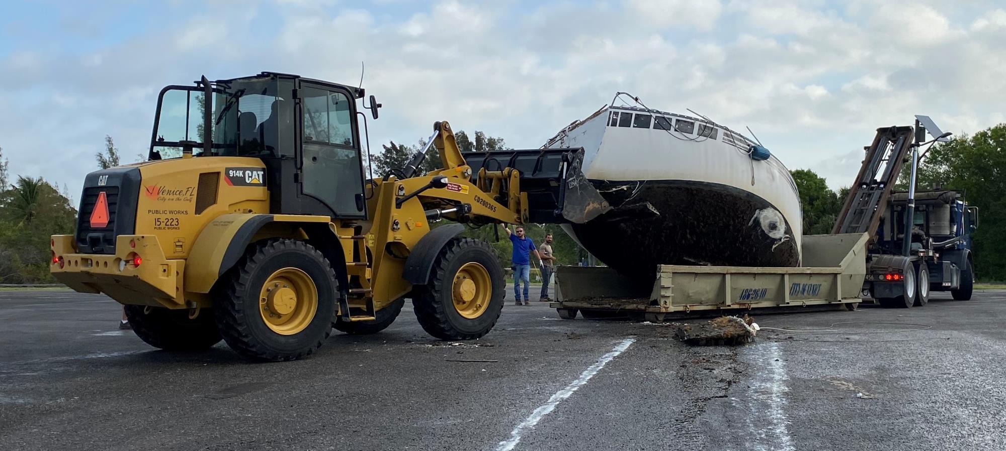 front loader loading boat on to roll off