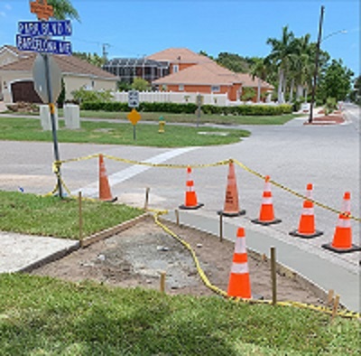 Sidewalk repair at Park Blvd N & Barcelona Ave  area blocked off by orange and while cones and caution tape